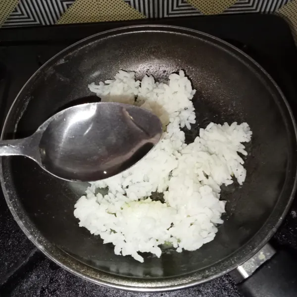 Letakkan nasi di teflon, kemudian tambahkan air, masak hingga nampak mendidih.