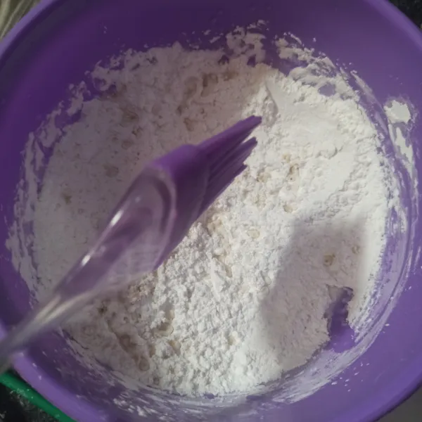 Letakkan tepung tapioka ke wadah, beri kaldu ayam bubuk, aduk rata. Percikkan air panas sedikit demi sedikit, sambil diaduk hingga membentuk bulatan kasar. Hentikan penggunakan air panas jika dirasa sudah cukup.