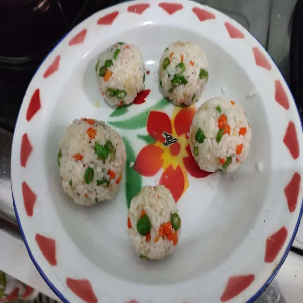 Bulat-bulatkan nasi dengan bantuan cling wrap, kemudian padat-padatkan.