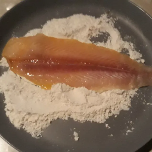 Balurkan ikan dori ke dalam tepung.
