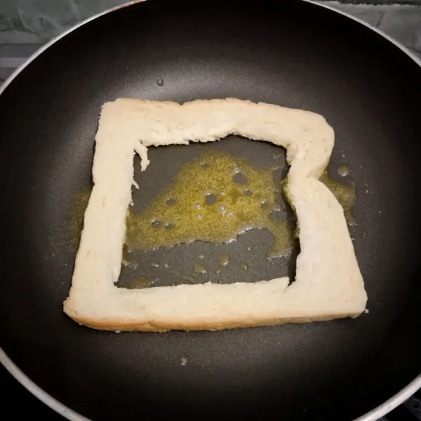 Panaskan mentega lalu masukkan roti yang tengahnya telah dipotong.