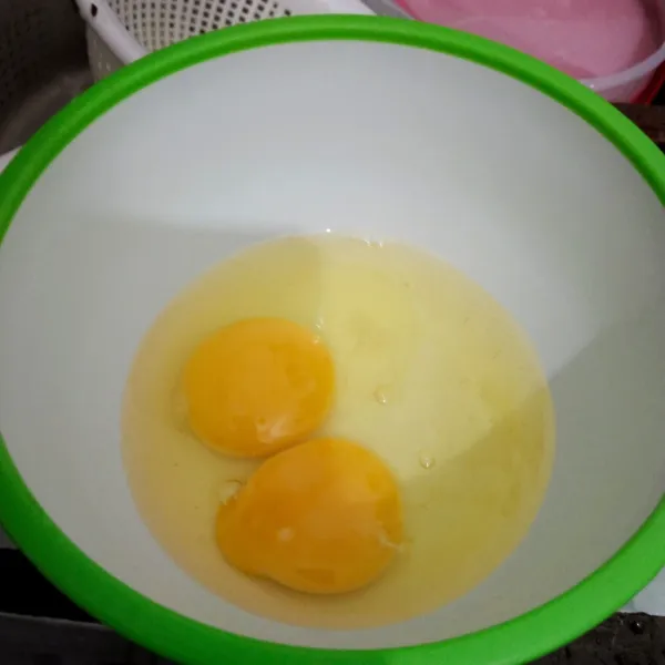 Kocok telur dalam wadah.