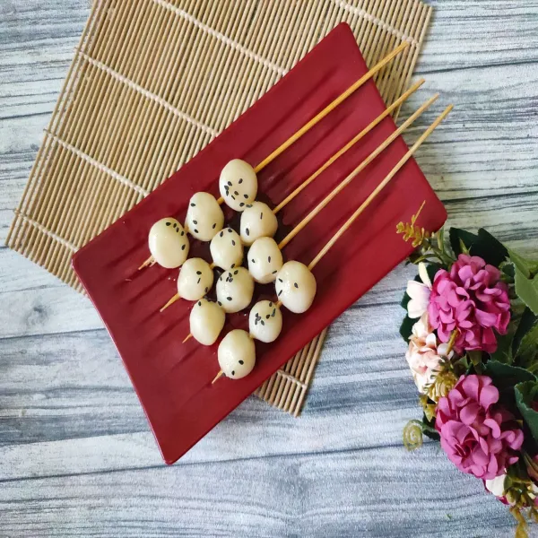 Tusuk dengan tusuk sate, salin ke atas piring saji, lalu taburi wijen hitam, dan beri saos dango. Potato Miratashi Dango siap disajikan.