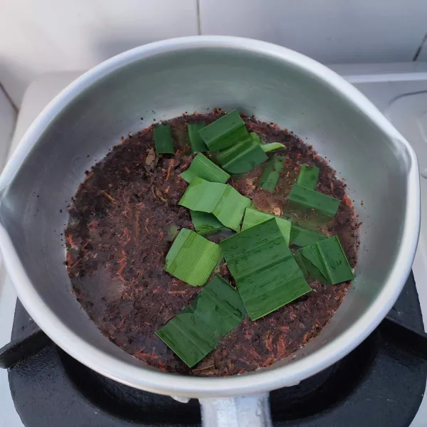 Masukkan air, daun teh, daun pandan dan gula ke dalam panci.
