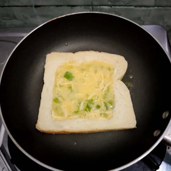 Masukkan telur ke dalam roti bagian yang kosong.