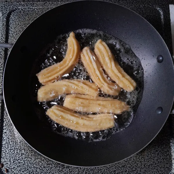 Panaskan minyak dengan api kecil, semprotkan adonan churros dengan menggunakan spuit bunga. Goreng hingga kecoklatan, angkat dan tiriskan.