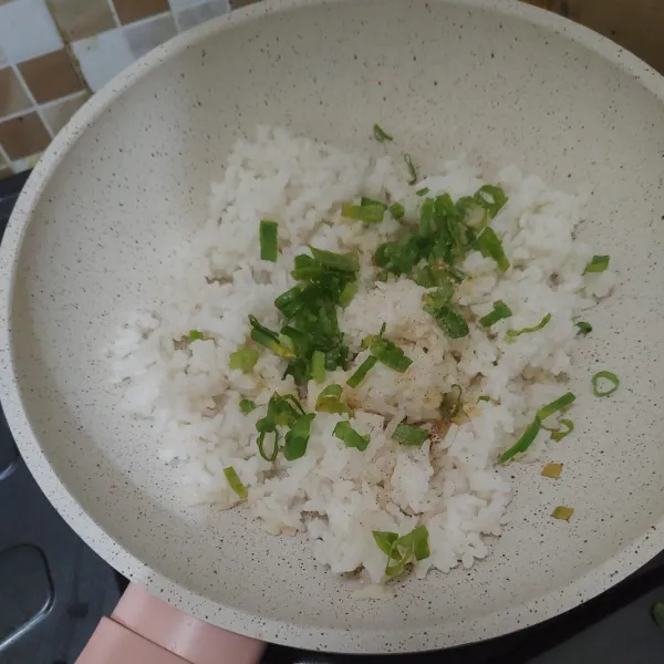 Masukan nasi ke dalam wajan sisa menggoreng sosis, tambahkan daun bawang iris. Bumbui dengan garam dan lada bubuk, aduk hingga merata. Angkat dan dinginkan.
