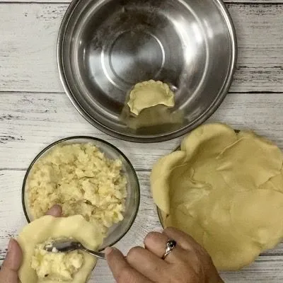Ambil kulit & beri satu sendok teh isian kentang, tutup & rapatkan. Lakukan sampai adonan habis.
