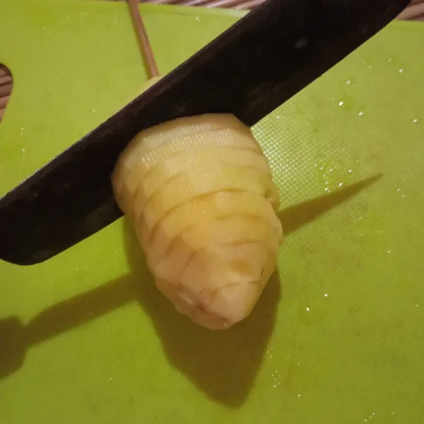 Potong kentang secara memutar dan tipis. 
Pastikan pisau mentok pada tusuk sate tapi kentang juga tidak boleh terputus.