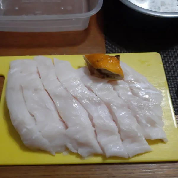 Beri perasan air lemon pada ikan kemudian iris-iris memanjang.