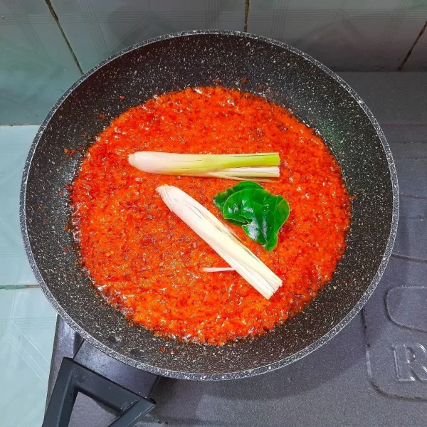 Masukan batang serai dan daun jeruk yang diremas-remas sebelumnya. Tumis sampai harum dan sambal mengeluarkan minyak dan berwarna lebih gelap.