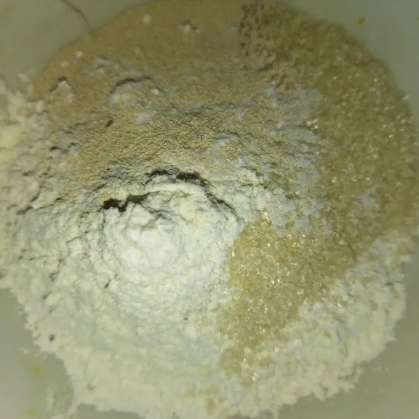 Siapkan wadah, masukkan tepung terigu, garam, ragi instan, gula pasir dan vanilli bubuk, aduk rata.