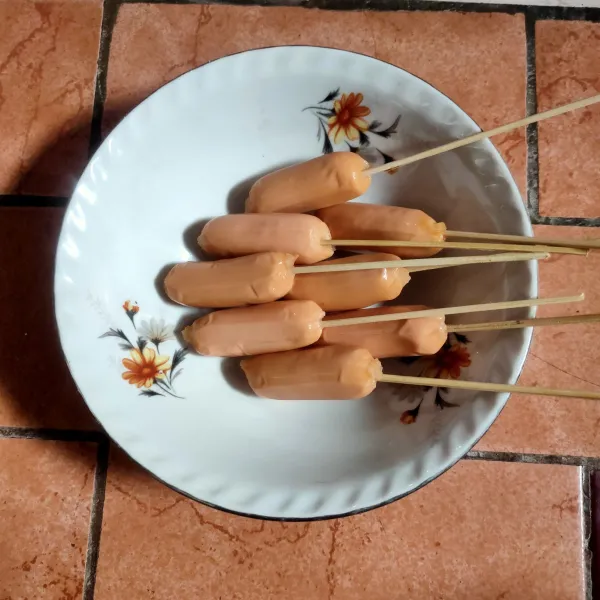 Tusuk sosis dengan menggunakan tusuk sate lalu sisihkan.