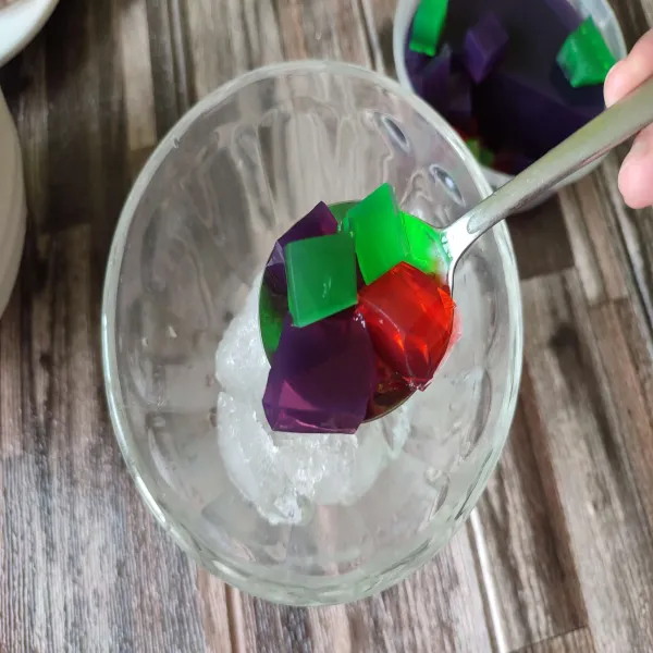 Masukkan es batu dalam gelas saji, kemudian beri jelly anggur, strawberry, serta melon.