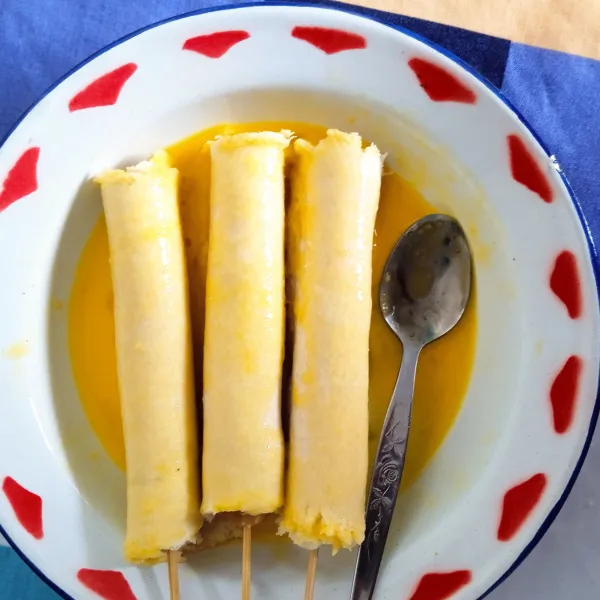Gulingkan corndog di telur.