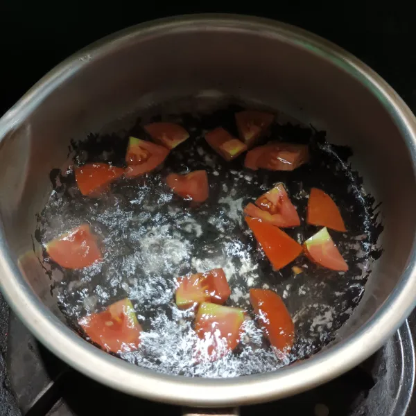 Didihkan air. 
Lalu masukkan tomat. 
Rebus sebentar.