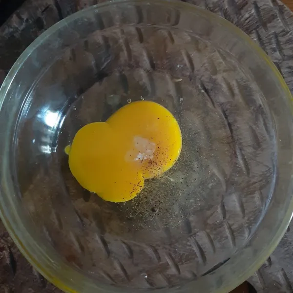 Kocok telur, garam, dan lada bubuk dalam wadah.