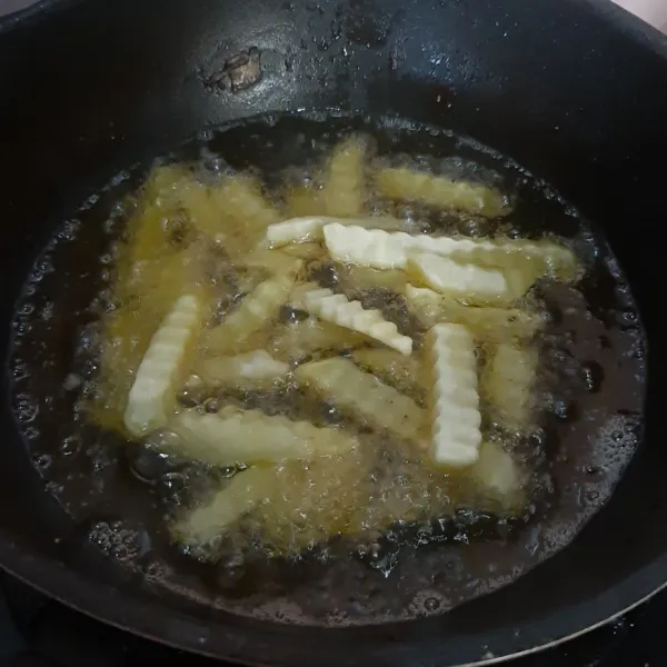 Goreng kentang beku hingga matang, lalu tiriskan.