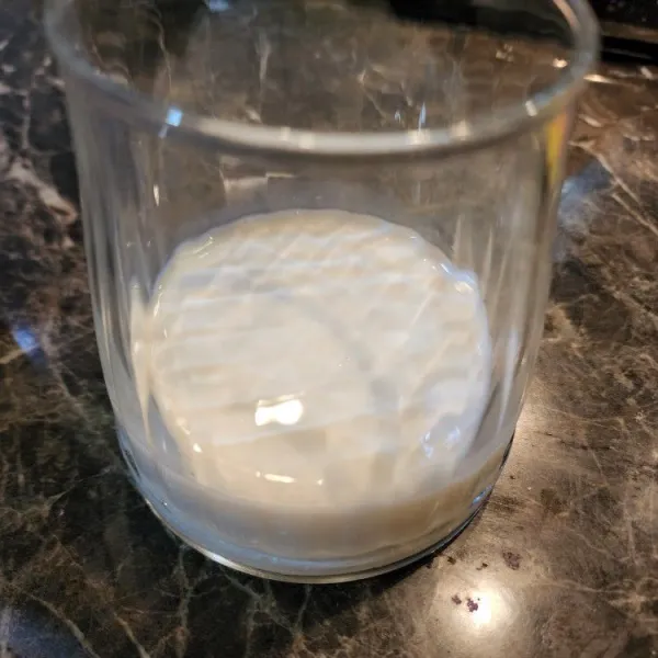 Dalam gelas, siapkan susu evaporasi dan tambahkan susu kental manis.