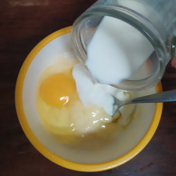 Masukkan telur dan susu cair sedikit demi sedikit sambil diaduk sampai rata.