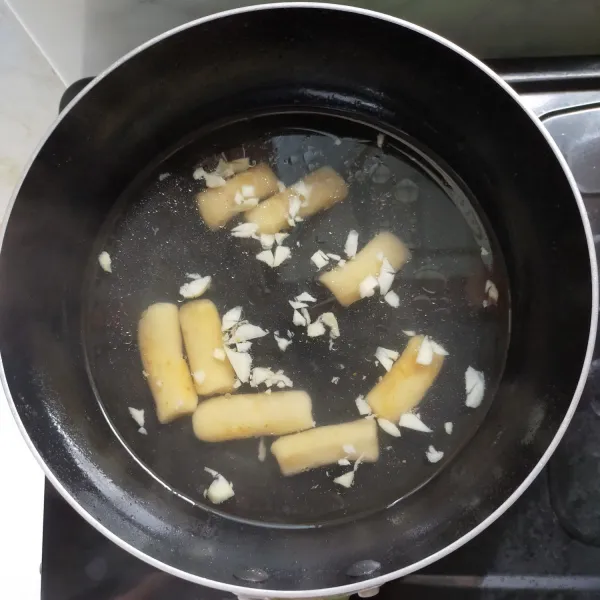 Rebus tteok dan bawang putih cincang hingga mendidih dan tteok matang.