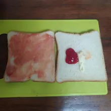 Olesi kedua lembar roti dengan saus sambal dan mayonnaise.