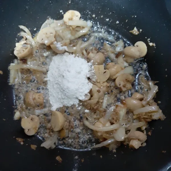 Tumis bawang bombay, bawang putih dan jamur hingga wangi. 
Kemudian masukkan tepung terigu. 
Aduk cepat.