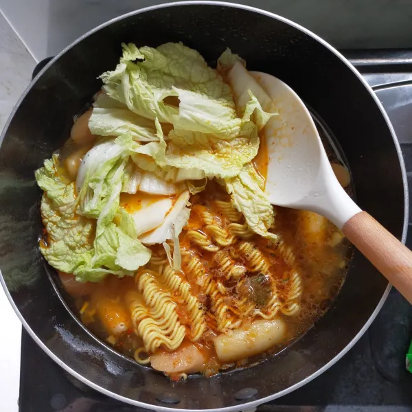Lalu bumbui dengan bumbu mie dan masukkan sayur kimchi.