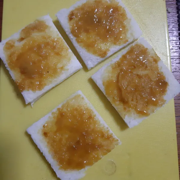 Bagi 1 lembar roti menjadi 4 bagian, lalu olesi dengan campuran mustard tadi.