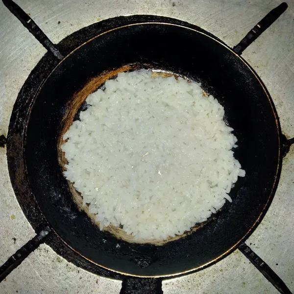 Tata nasi di atas teflon sambil dipipihkan menggunakan sendok.