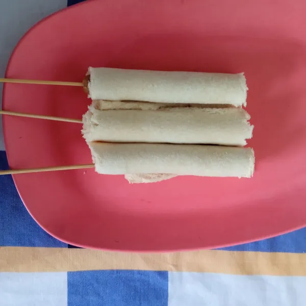 Gulung sosis dengan roti tawar, lalu lekatkan dengan telur.