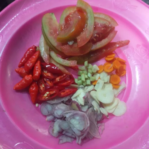 Iris tipis bawang merah, bawang putih, serai, dan kunyit, lalu potong-potong cabai dan tomat.