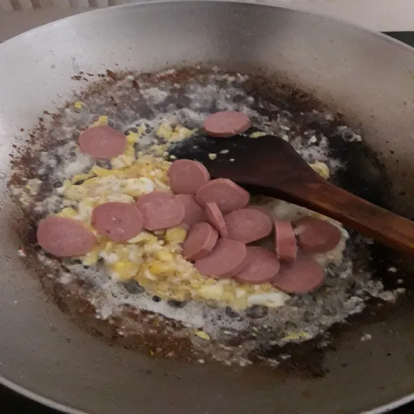 Masukkan telur, orak-arik sampai matang. Tambahkan juga sosis, aduk sebentar.