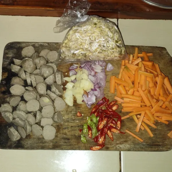 Siapkan semua bahan, iris tipis bawang merah, bawang putih dan cabai, kemudian potong wortel berbentuk korek api, serta potong bakso menjadi 3 bagian.