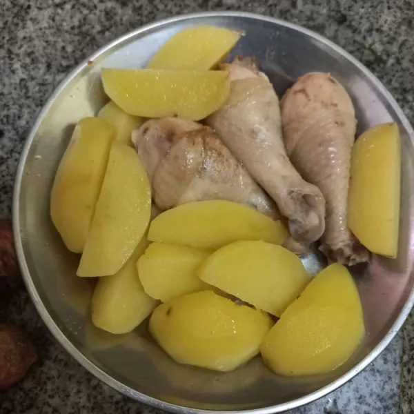 Rebus potongan kentang dan paha ayam hingga matang, kemudian tiriskan.