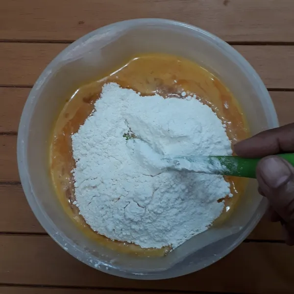 Masukkan tepung terigu secara bertahap ke dalam adonan labu kuning sambil diaduk balik hingga asal rata saja.