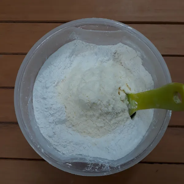 Masukkan ke dalam mangkuk : tepung terigu, soda kue, baking powder, vanili bubuk dan susu bubuk fullcream. Aduk lalu saring.