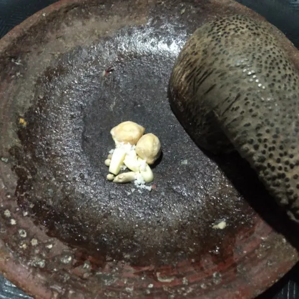 Haluskan bawang putih, kemiri, lada bubuk, dan garam sampai halus.