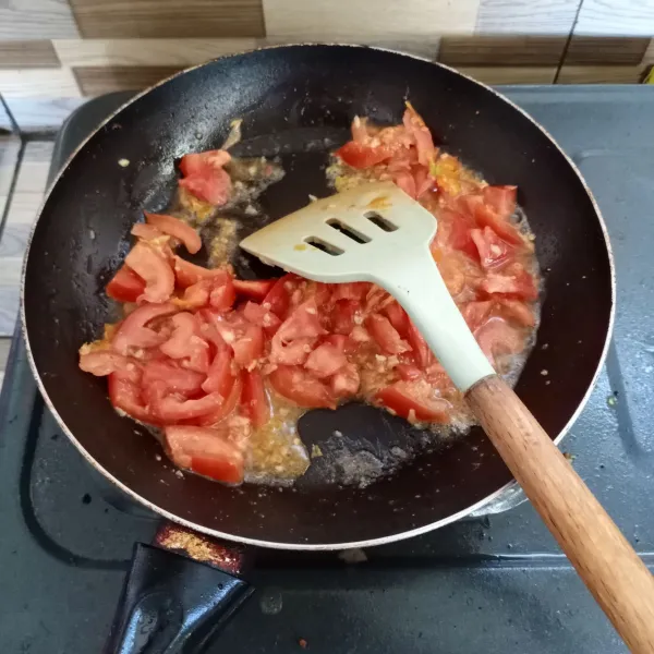 Kemudian masukkan irisan tomat, aduk rata.