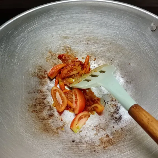 Kemudian masukkan cabe rawit utuh dan potongan tomat, tumis sampai harum.