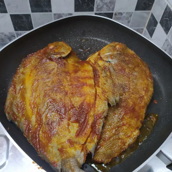 Olesi ikan dengan bumbu bakar di kedua sisi. Panaskan grill pan dengan sedikit olesan minyak goreng. Bakar ikan sampai matang di satu sisi.