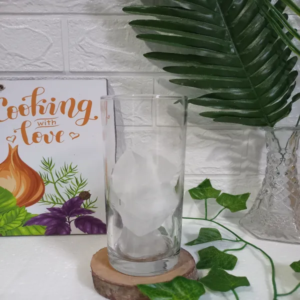 Siapkan gelas saji, masukkan es batu ke dalam gelas.