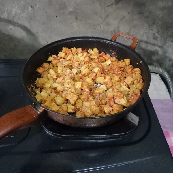 Masukkan kentang dan tempe. Bumbui dengan garam, gula, dan penyedap rasa. Aduk sampai rata dan koreksi rasa.