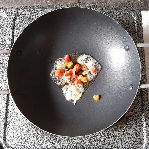 Panaskan minyak, tumis bawang putih dan cabe rawit hingga harum.