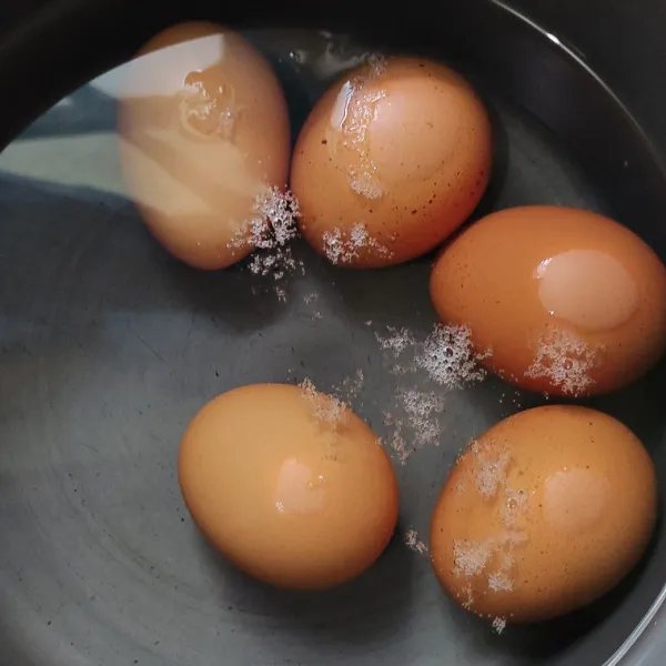 Rebus telur 10 menit saat air mendidih, kupas dan cuci bersih, tiriskan.