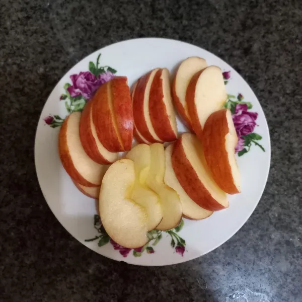 Potong-potong apel dan pindahkan apel pada wadah saji.