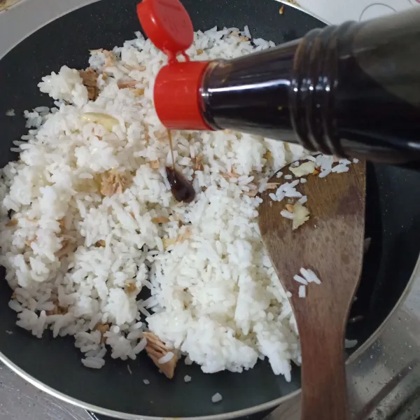 Masukkan nasi, tambahkan kecap, aduk rata.