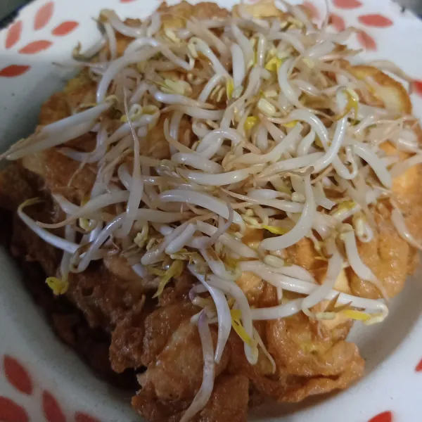 Tata diatas piring tahu telur lalu beri toge diatasnya.