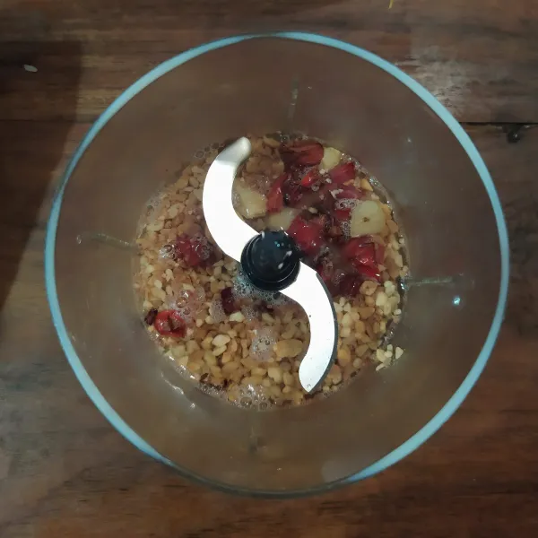 Membuat bumbu kacang : goreng cabe merah dan bawang putih.
Masukkan ke dalam blender beserta kacang tanah goreng dan setengah bagian air.
Proses hingga halus.