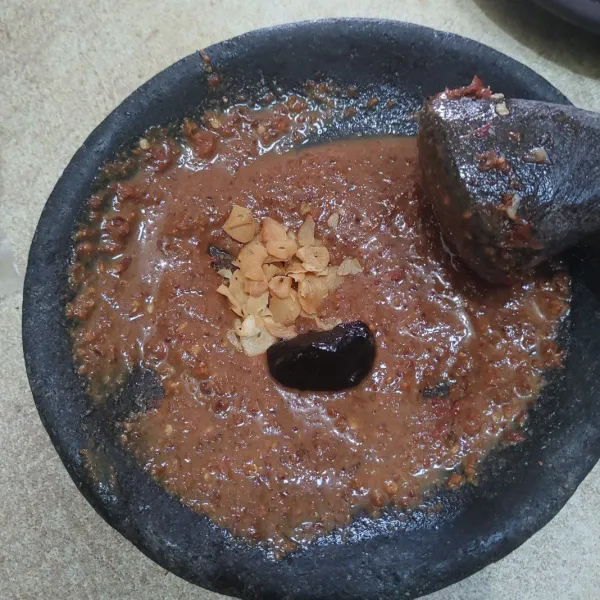 Tambahkan bawang putih goreng dan petis, haluskan kembali dan tambahkan sedikit air.